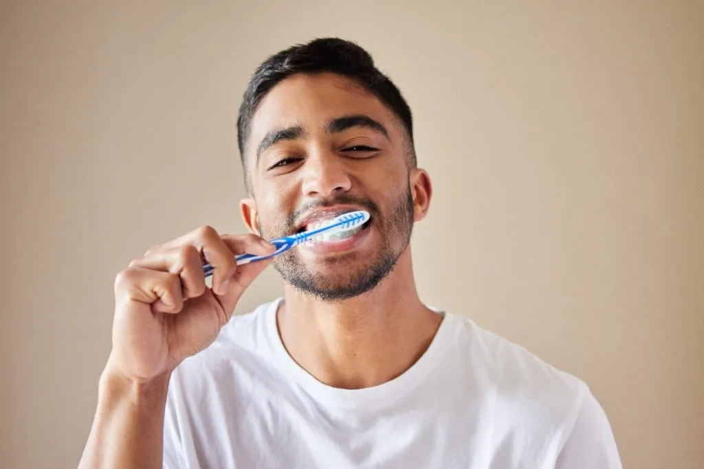 a man brushing his teeth correctly